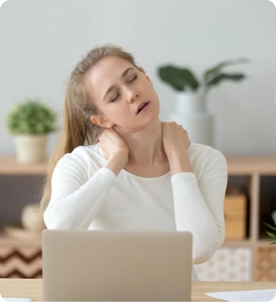 Woman at a laptop rubbing her sore neck