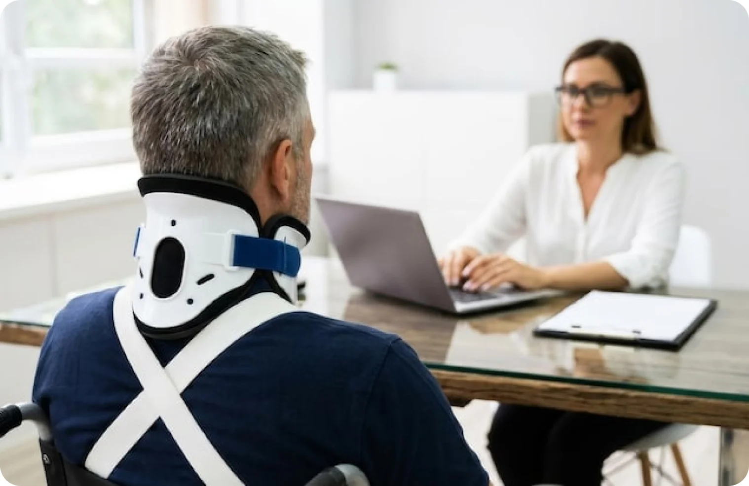Patient in a neck brace consulting with the clinic team